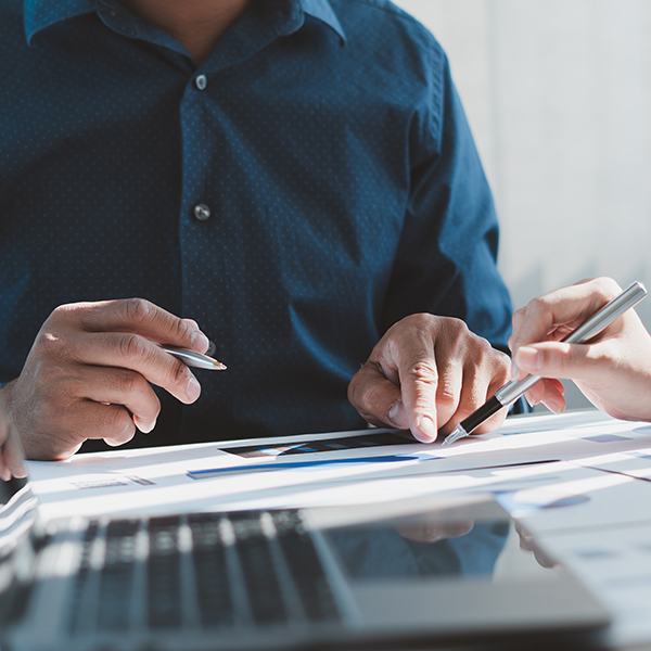 Two people reviewing plans together at a conference table.