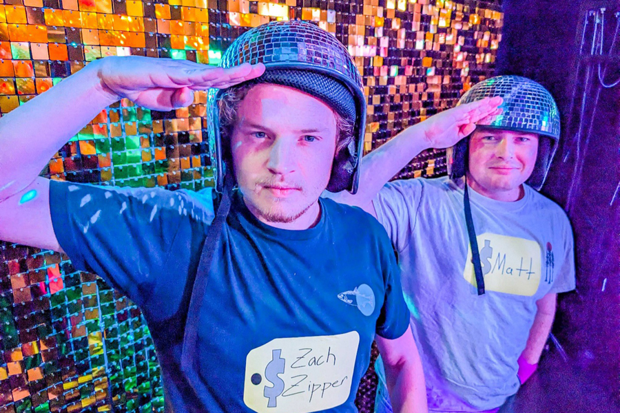 Two men salute wearing disco ball helmets