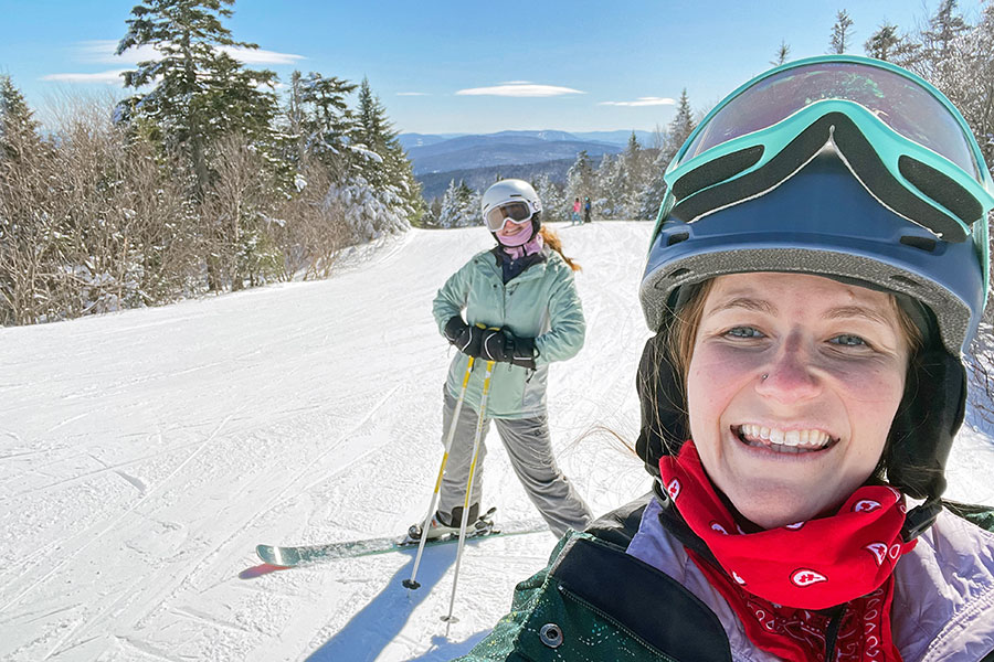 Two women pose on a ski slope