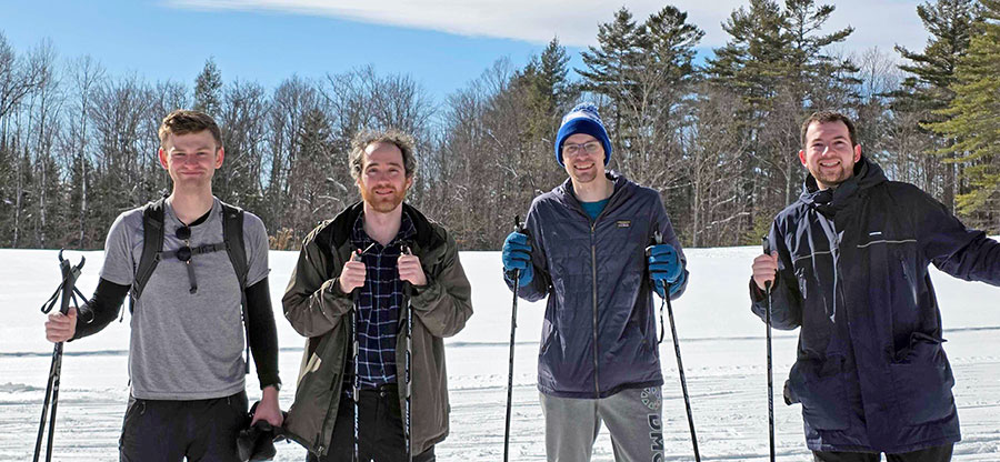 Four men pose with cross-country skis