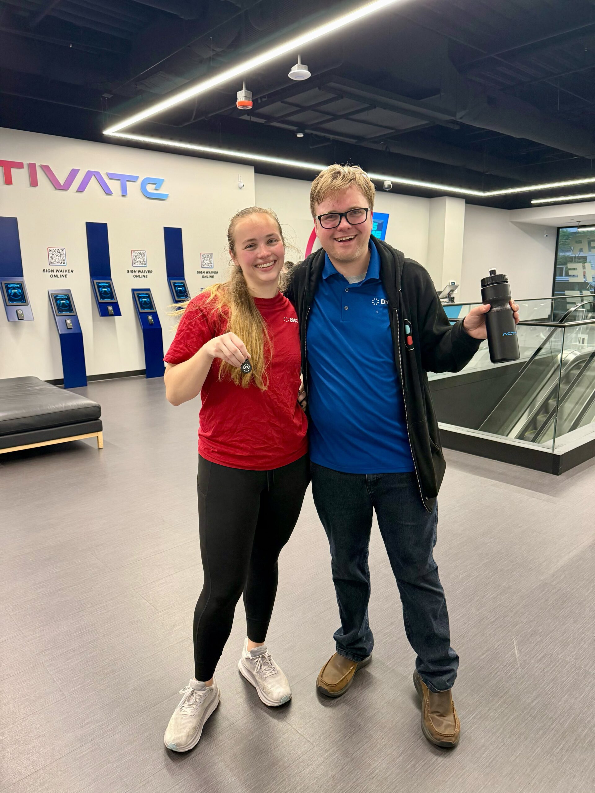 Two DMC employees taking a picture together in the lobby at Activate Games.