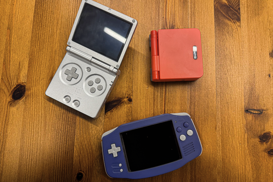 Three handheld gaming devices on table